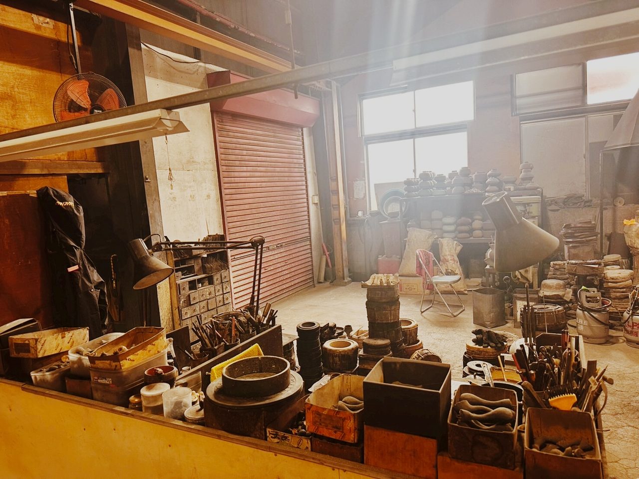 作業台に並ぶ工具、箱に分けられた道具、赤いシャッター